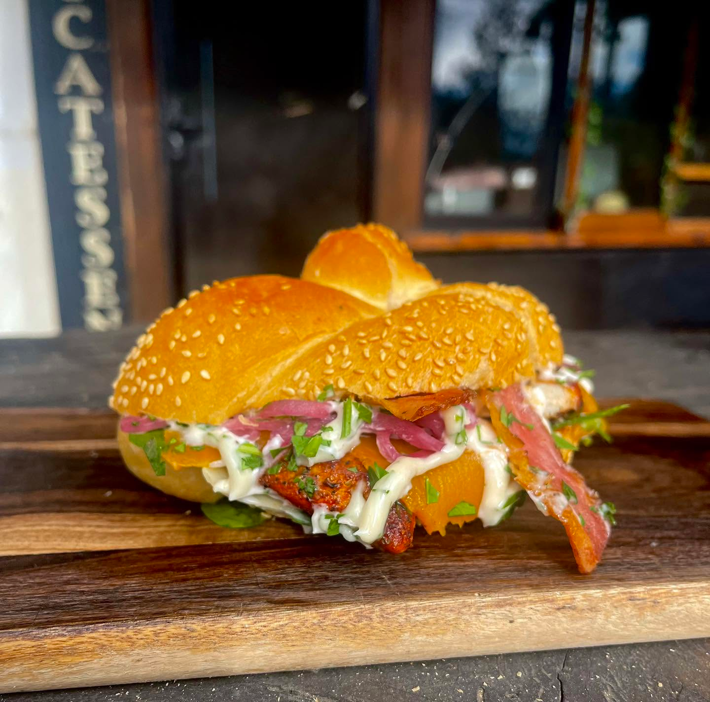 Loaded beef sub with caramelised onions, fresh herbs, and green onions on a toasted roll